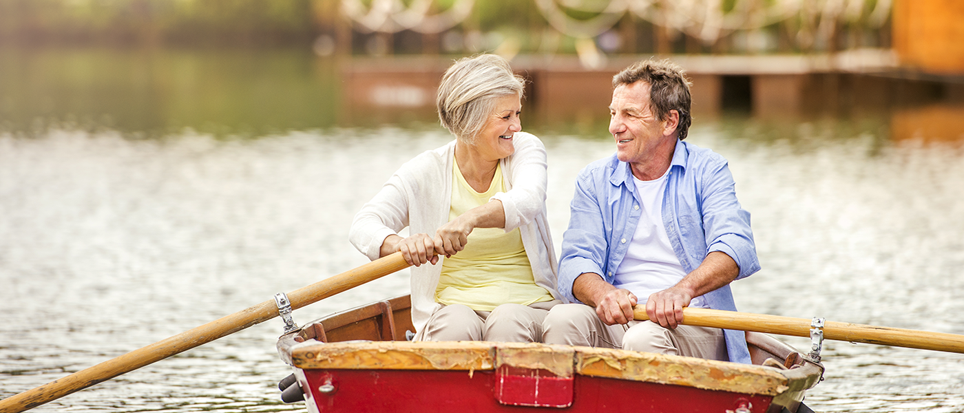A retired couple rowing a boat on a lake representing what you can do with an equity release mortgage.